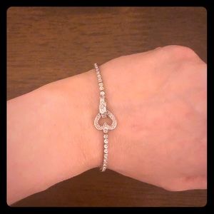 White gold diamond bracelet with heart detail.